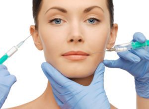 Dermal filler patient with needles poised