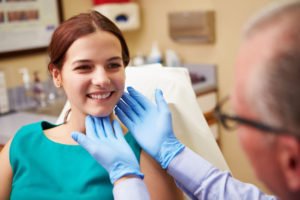 Tampa Plastic Surgeon examines a patient with blue gloves