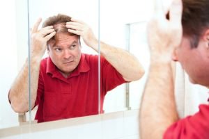 Tampa Hair Restoration Patient looking into the mirror
