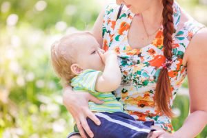 Tampa Breast Augmentation model breastfeeding her baby