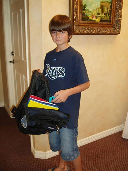 boy posing for backpack giveaway photo