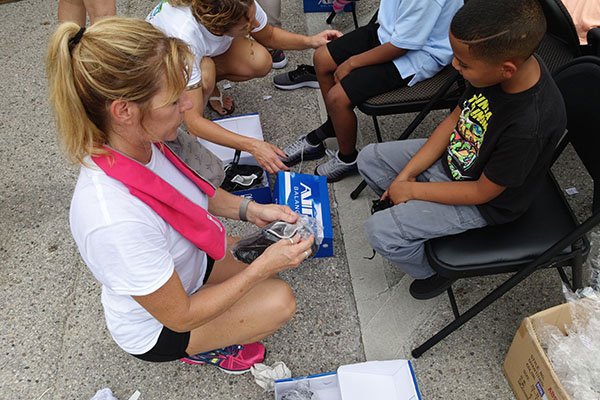 Sneakers on Students 2017 woman giving shoes to child